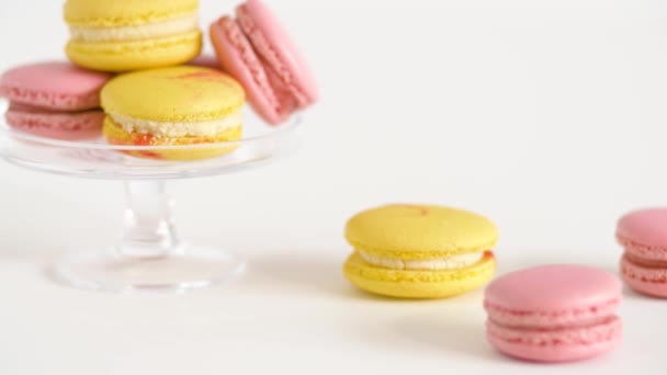 Žlutá a růžová macarons na sklo stojan a tabulka — Stock video