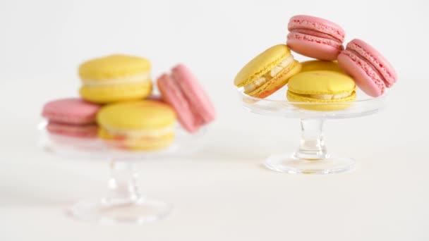 Gula och rosa macarons på glas står — Stockvideo