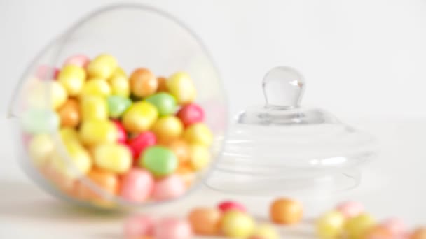 Close up of scattered candy drops and jar on table — Stock Video