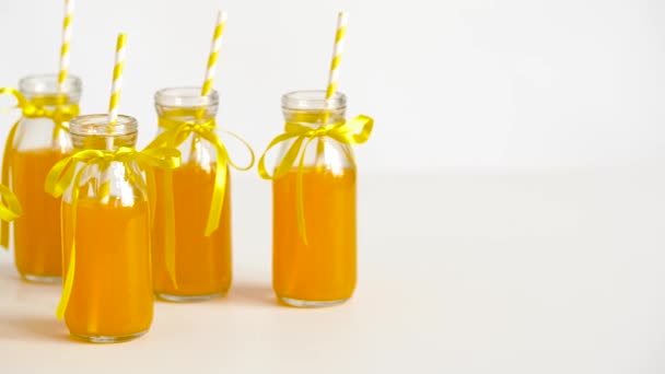 Juice or lemonade in glass bottles with straws — Stock Video