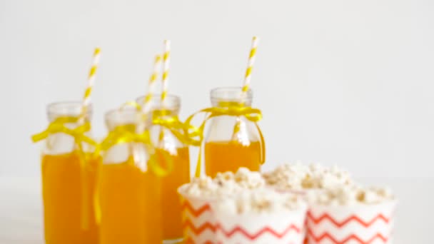 Лимонад или сок в стеклянных бутылках и попкорне — стоковое видео