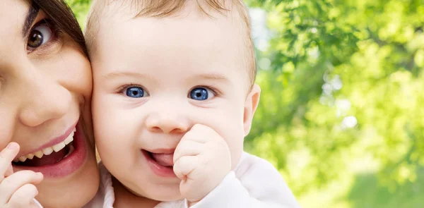 Mãe com bebê sobre fundo natural verde — Fotografia de Stock