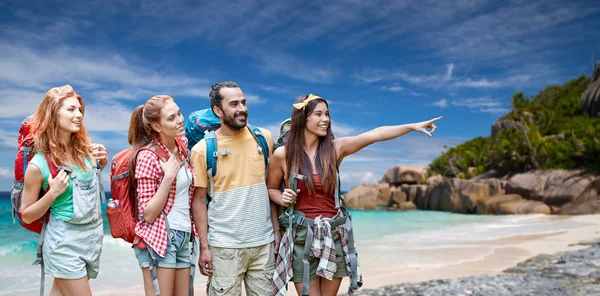 Friends with backpacks over seychelles beach — Stock Photo, Image