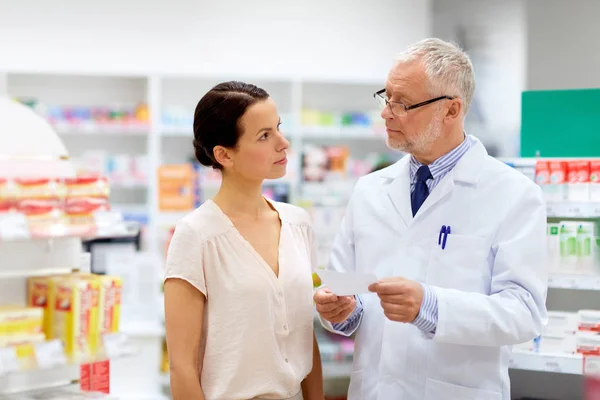Lékárník a žena s předpisem v lékárně — Stock fotografie