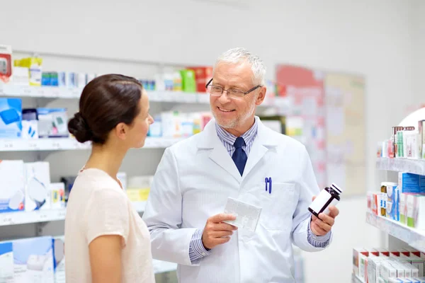 Аптекарь и женщина с лекарством в аптеке — стоковое фото
