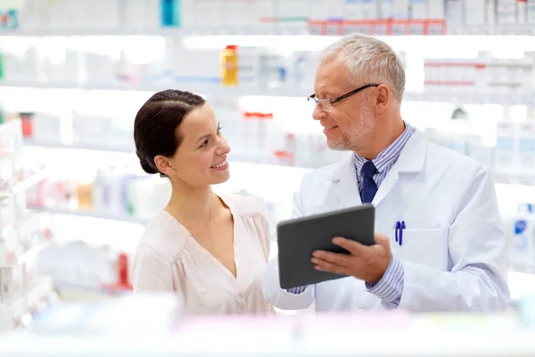 Boticario y cliente con tableta PC en la farmacia — Foto de Stock