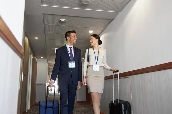Equipe de negócios com sacos de viagem no corredor do hotel — Fotografia de Stock