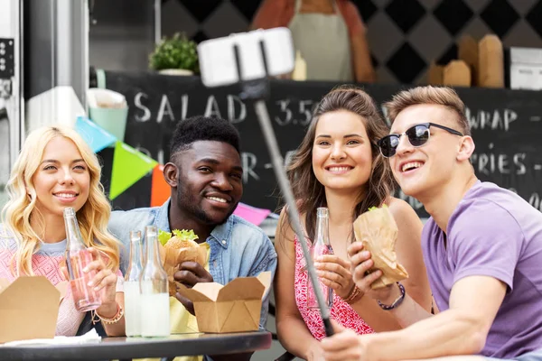 Felices jóvenes amigos tomando selfie en camión de comida — Foto de Stock