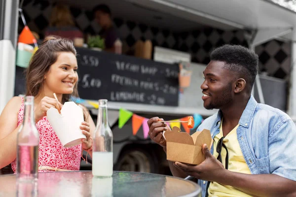 Mixte couple de course manger et parler au camion alimentaire — Photo