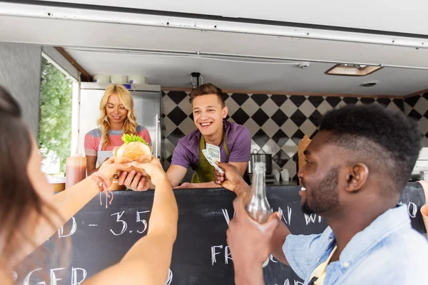 Happy customers buying burger at food truck — Stock Photo, Image