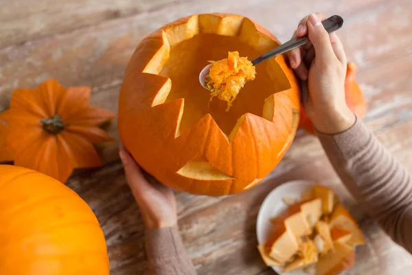 Nahaufnahme einer Frau, die Halloween-Kürbis schnitzt — Stockfoto