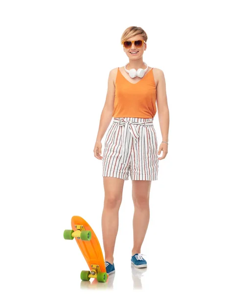 Улыбающаяся девочка-подросток со скейтбордом над белым — стоковое фото