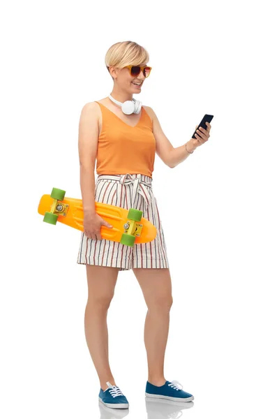 Teenage girl with skateboard and smartphone — Stock Photo, Image