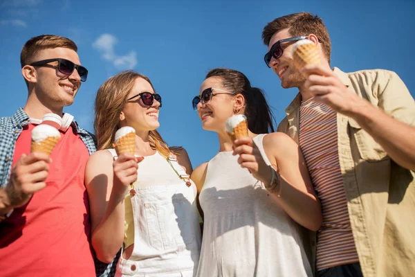 Группа улыбающихся друзей с мороженым на открытом воздухе — стоковое фото