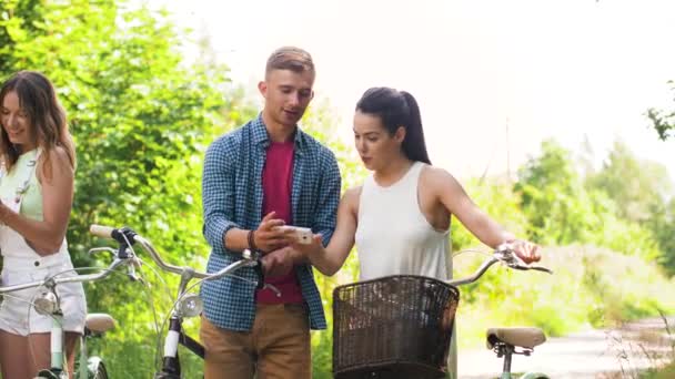 Amigos con bicicletas y smartphones en el parque — Vídeo de stock