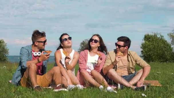 Vänner som äter pizza på picknick i tallinn park — Stockvideo