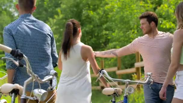 Glückliche Freunde mit Fahrrädern tanzen im Sommerpark — Stockvideo