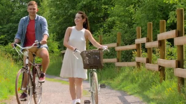 Feliz pareja con bicicletas de engranaje fijo en verano — Vídeo de stock