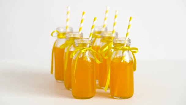 Jus ou limonade en bouteilles de verre avec des pailles — Video