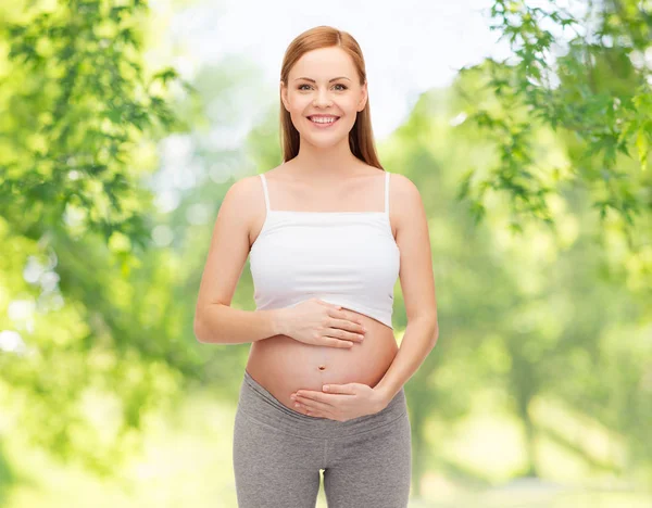 Szczęśliwa Kobieta w ciąży dotykając jej nagi brzuch — Zdjęcie stockowe