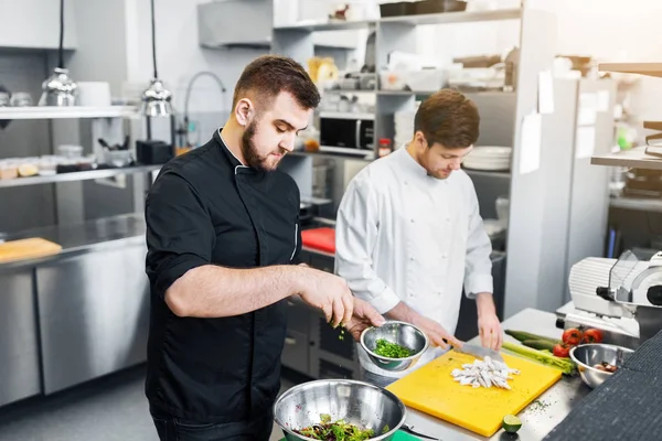 Chef-kok en kok koken eten bij restaurant keuken — Stockfoto