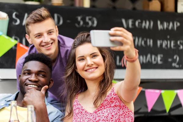 Felices jóvenes amigos tomando selfie en camión de comida — Foto de Stock