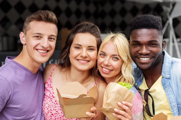 Gelukkige vrienden met afhaalmaaltijden voedsel outdoors — Stockfoto