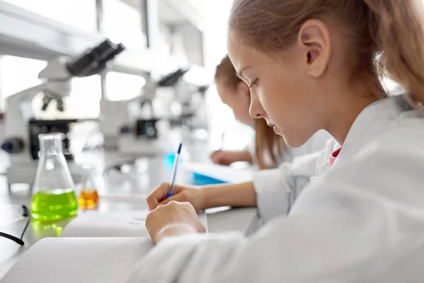 Dziewczyna studiuje chemii w szkole laboratorium — Zdjęcie stockowe