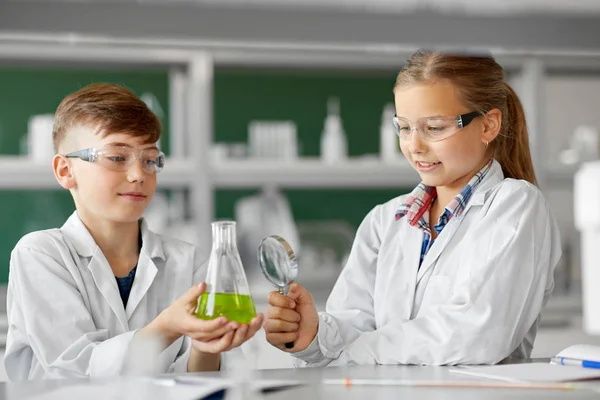Çocuklarla şişesi ve büyüteç Kimya sınıfı — Stok fotoğraf
