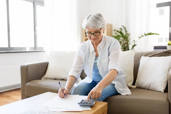 Senior kobieta z pieniędzy i rachunki w domu — Zdjęcie stockowe