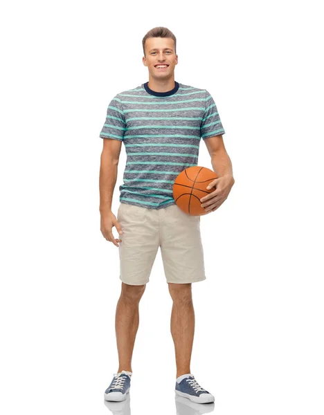 Hymyilevä nuori mies koripallon kanssa — kuvapankkivalokuva