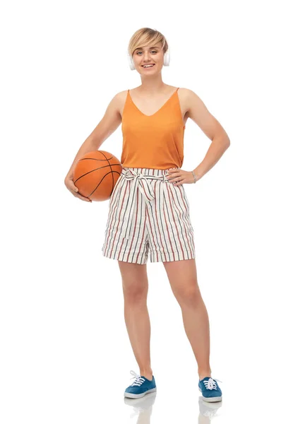 Lachende tienermeisje in hoofdtelefoon met basketbal — Stockfoto