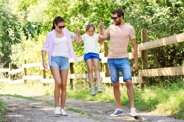 Счастливая семья, гуляющая в летнем парке — стоковое фото