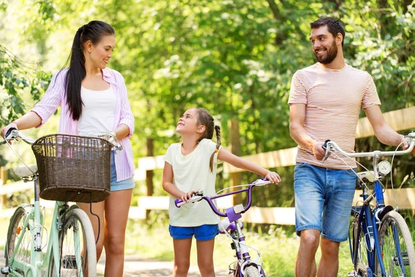 Ευτυχισμένη οικογένεια με ποδήλατα στο πάρκο του καλοκαιριού — Φωτογραφία Αρχείου