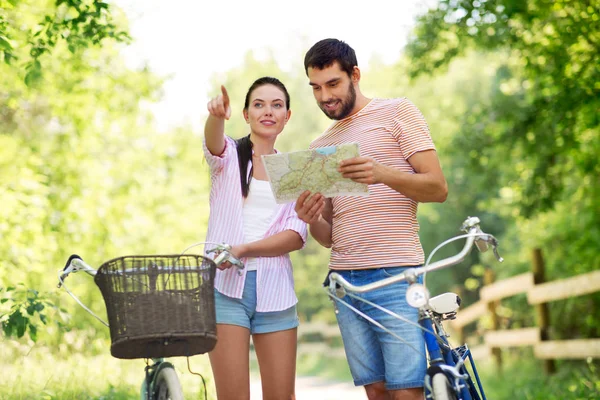 Echtpaar met kaart en fietsen op land in de zomer — Stockfoto