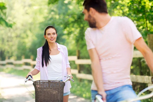 Coppia felice con biciclette al parco estivo — Foto Stock