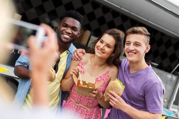 Vänner med takeaway mat fotografering utomhus Stockbild