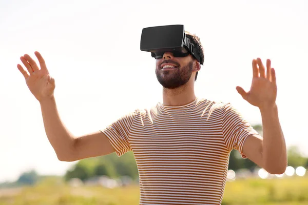 Uśmiechnięty mężczyzna w zestaw wirtualnej rzeczywistości na zewnątrz — Zdjęcie stockowe