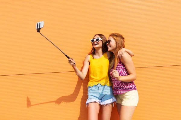 Chicas adolescentes tomando fotos por palo selfie — Foto de Stock