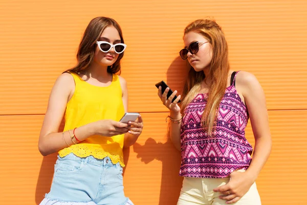 Chicas adolescentes con teléfonos inteligentes en verano al aire libre —  Fotos de Stock