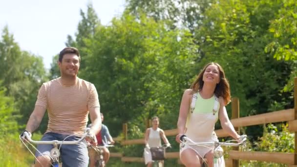 Amigos felices montando bicicletas de engranaje fijo en verano — Vídeo de stock