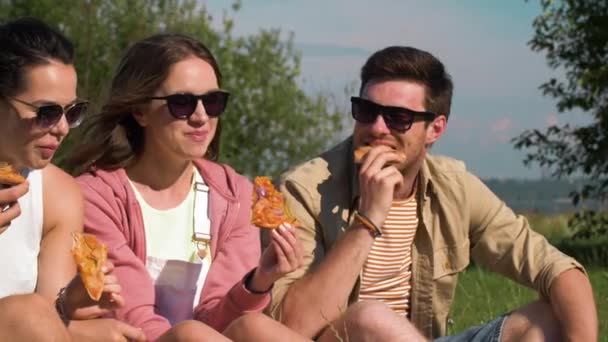 Друзья едят пиццу на пикнике в летнем парке — стоковое видео