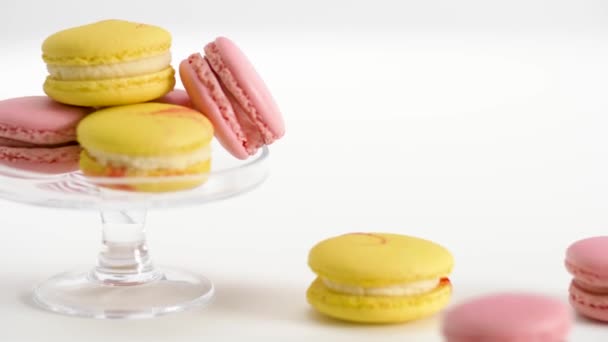 Gula och rosa macarons på glas monter och tabell — Stockvideo