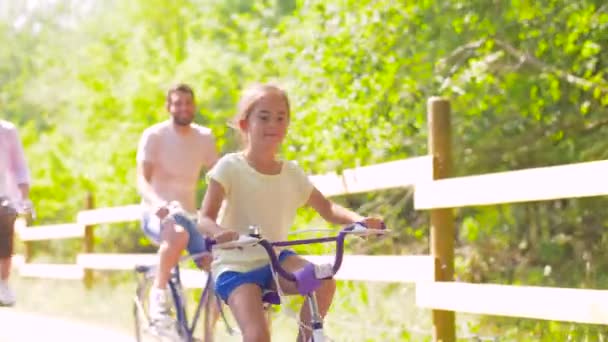 Felice famiglia a cavallo biciclette nel parco estivo — Video Stock