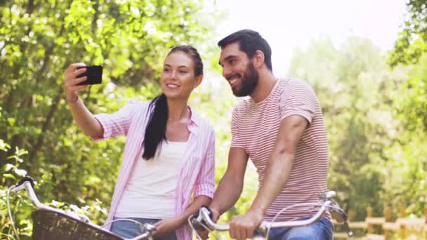 Pareja con bicicletas tomando selfie por smartphone — Vídeo de stock