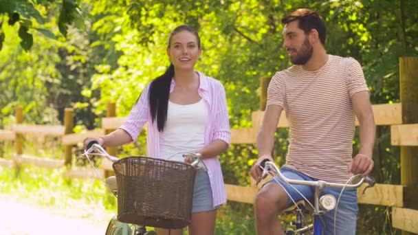 Casal feliz com bicicletas falando no parque de verão — Vídeo de Stock