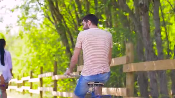 Ευτυχισμένη οικογένεια ιππασία ποδήλατα στο πάρκο του καλοκαιριού — Αρχείο Βίντεο