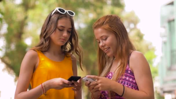 Девушки-подростки со смартфонами в летнем парке — стоковое видео