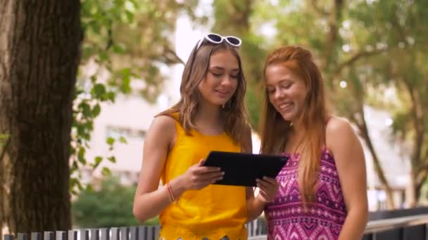 Teenage girls with tablet pc in summer park — Stock Video