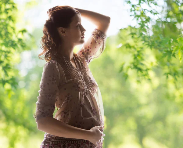 Zwangere vrouw over groene natuurlijke achtergrond — Stockfoto